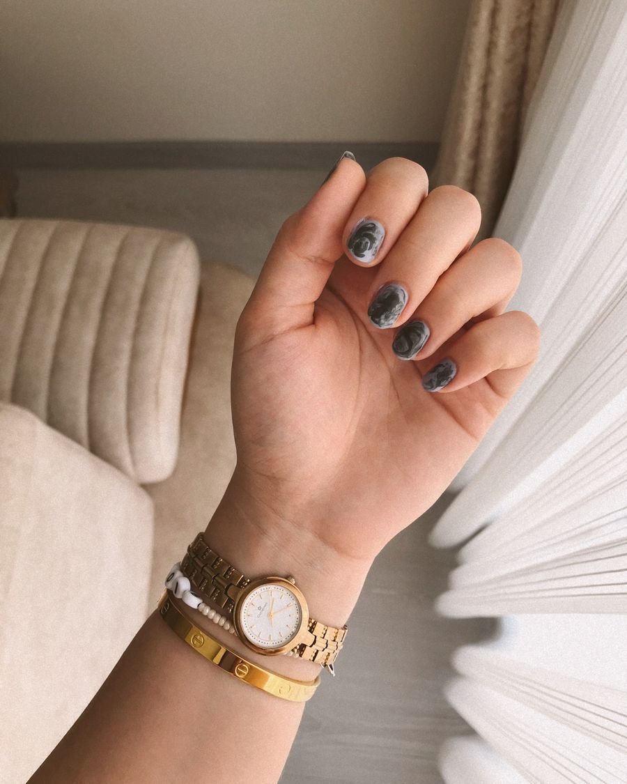 Graue Blüten-Nail-Art mit goldener Uhr
